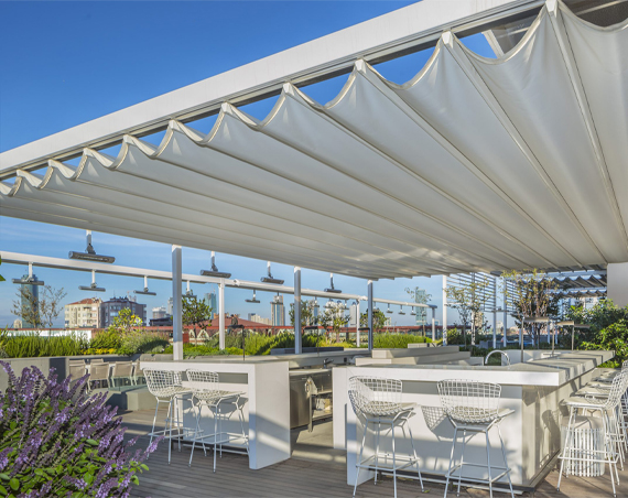 White wavy fabric roof attached to aluminium rail in an outdoor dining space