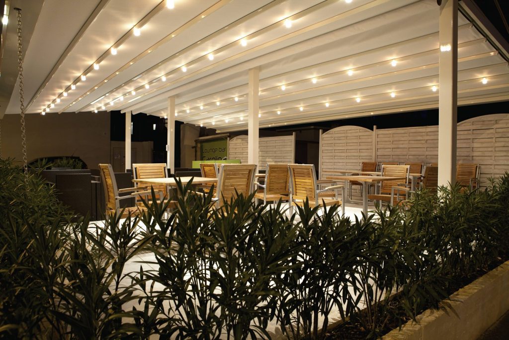 White inclined roof pergola with white lights & central aluminium pillar